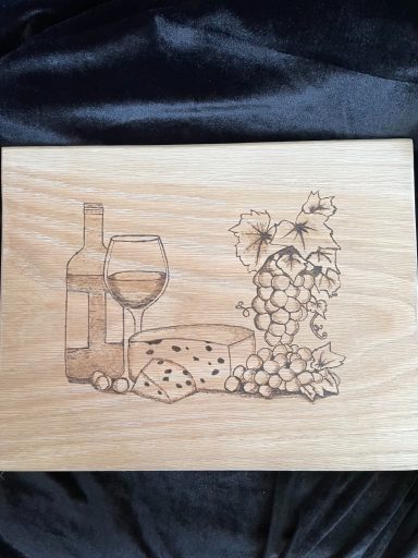 Wooden board featuring a wine bottle, glass, cheese, and grapes illustration.